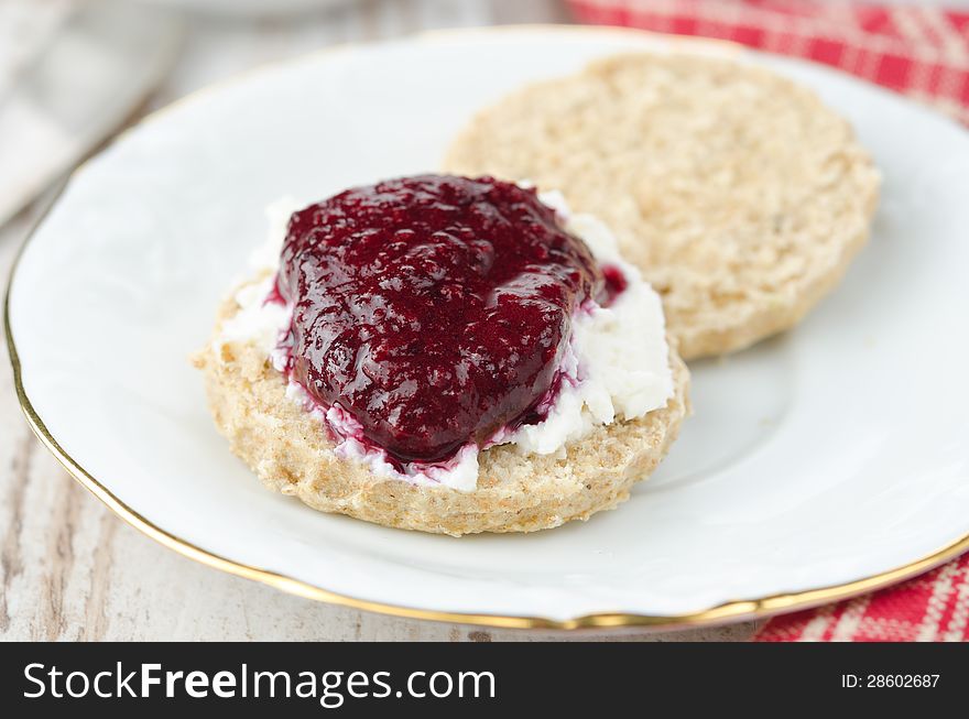 Scone with goat cheese and jam on a plate closeup horizontal