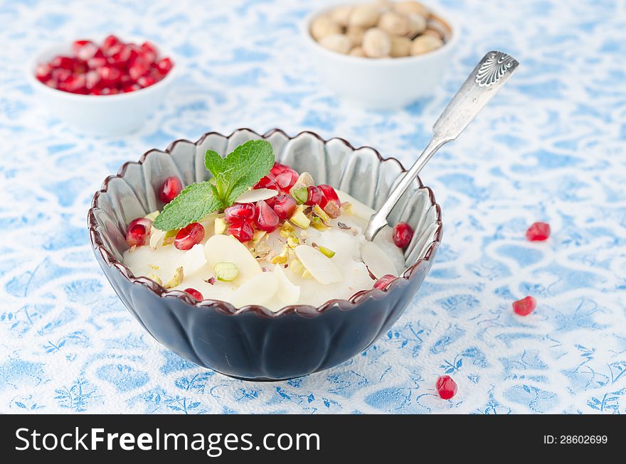 Semolina dessert with pomegranate seeds and pistachios in a bowl