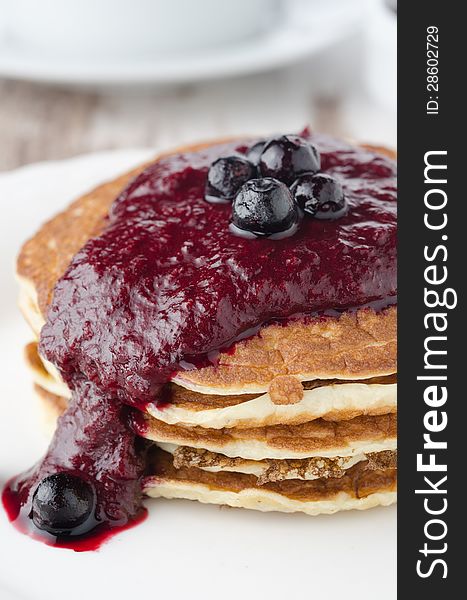 Stack of pancakes with black currant jam on a plate closeup. Stack of pancakes with black currant jam on a plate closeup