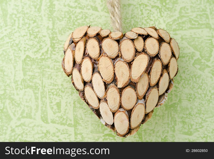 Wooden heart closeup on a green background