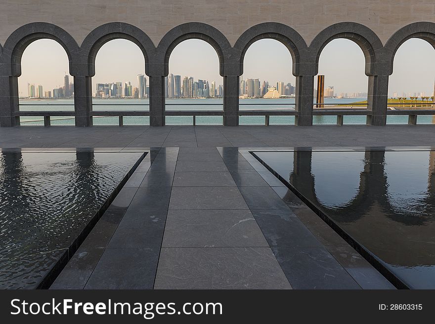The Doha skyline captured through the arches behind the museum of Islamic art in Doha. The Doha skyline captured through the arches behind the museum of Islamic art in Doha.