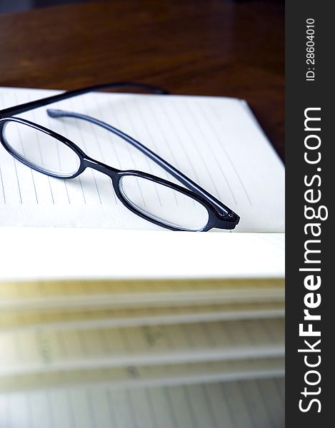 Black frame eyeglasses put on notebook