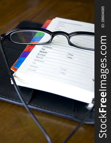 Eyeglasses put on page of personal organizer. Eyeglasses put on page of personal organizer