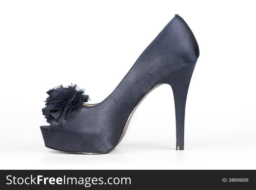 Stylish satin-finish ladies stiletto shoe in dark blue with an open toe and a floral decoration for classical formal wear on a white studio background