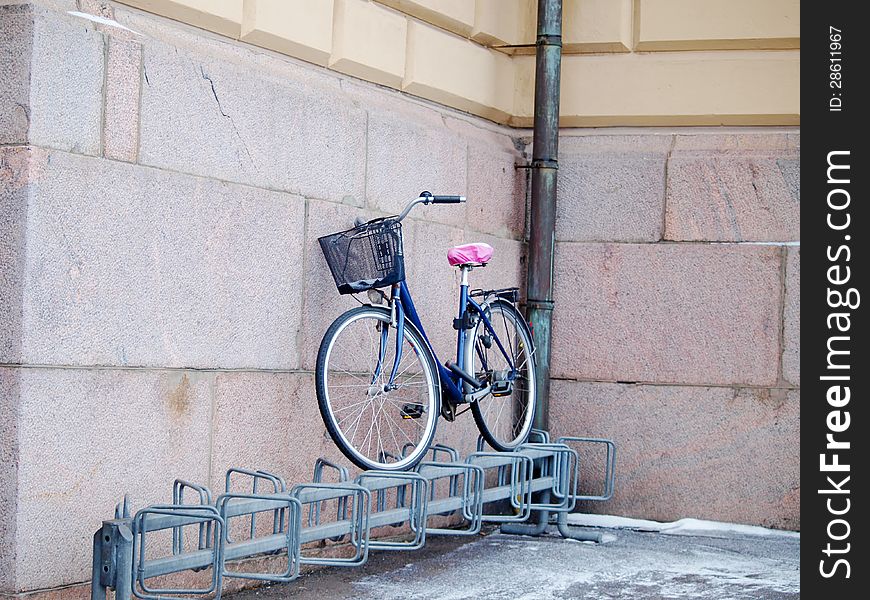 Bike left above a bike rack, towards a stone brick building