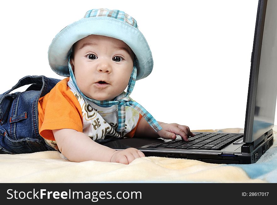 Cute baby is working on laptop and looking at the camera. Cute baby is working on laptop and looking at the camera