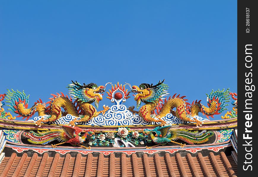 Twin Chinese dragon on the temple roof with blue sky background