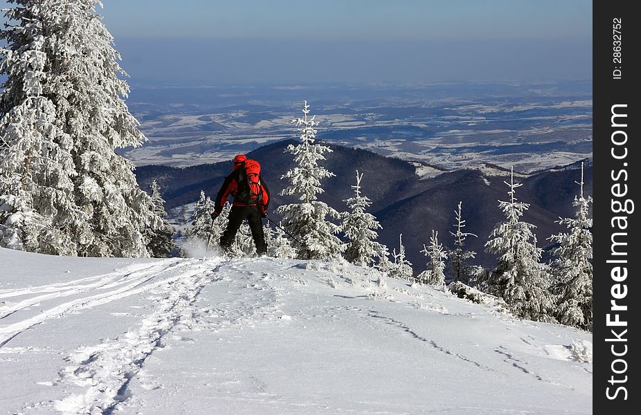 This image shows a skier that was getting down from a mountain in a beautiful sunny winter day. This image shows a skier that was getting down from a mountain in a beautiful sunny winter day.