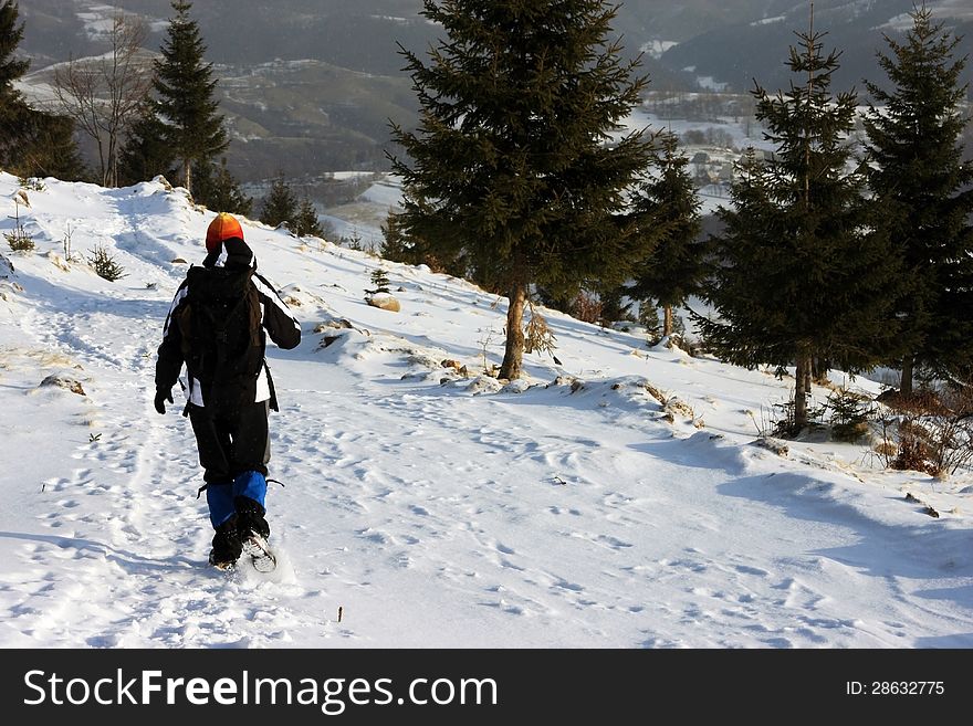 Young woman descending from the mountain during winter time. Young woman descending from the mountain during winter time.