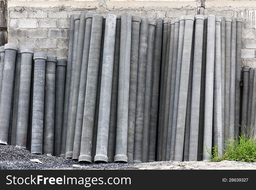 Stack of many concrete drainage pipe on wall in construction site