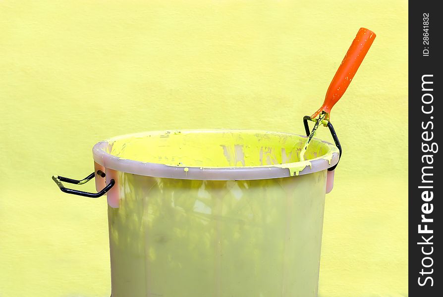 Paint-roller and Paint bucket with paint on a green background