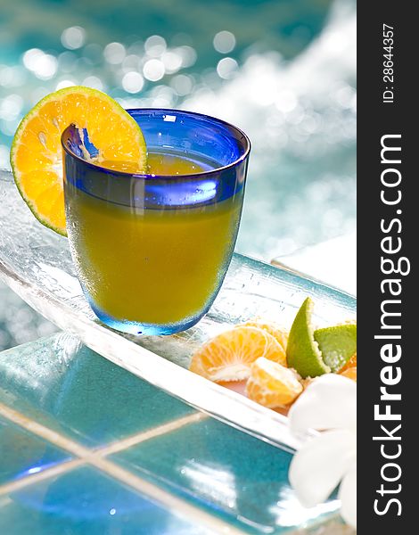Orange juice decorated with orange in blue glass