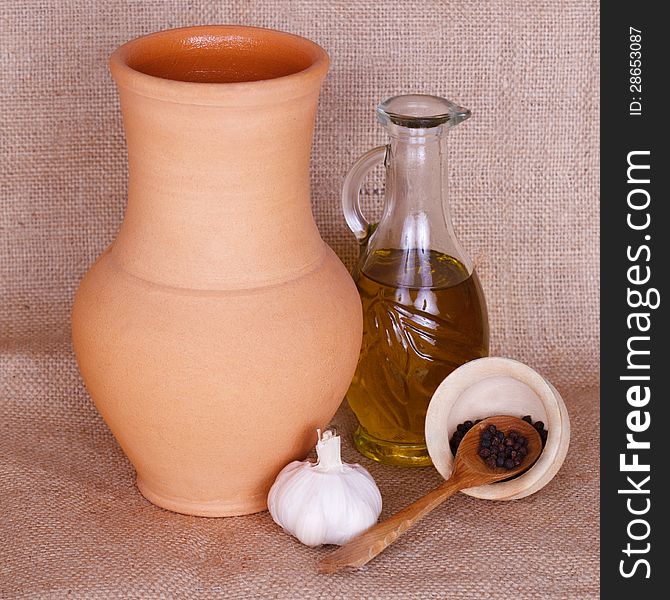 Spices, oil and pitcher against rough fabric