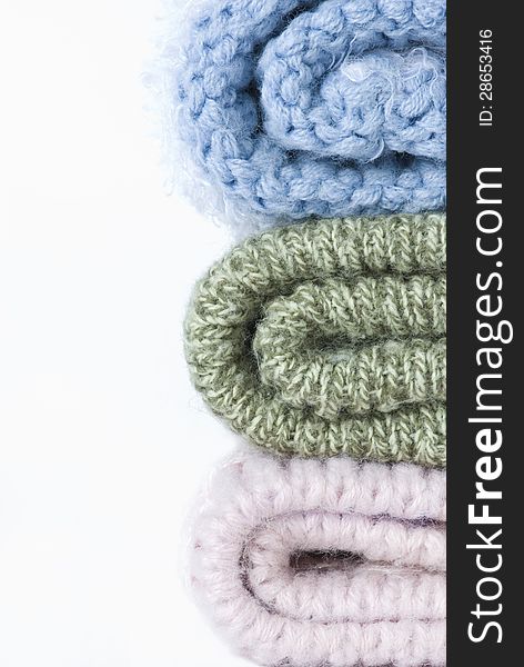 Stack of colorful knitted woolen winter hats on a white background. Stack of colorful knitted woolen winter hats on a white background