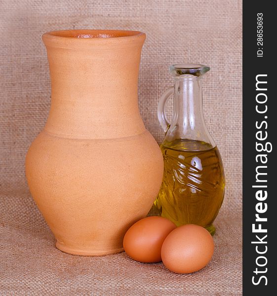 Egg, oil and pitcher against rough fabric