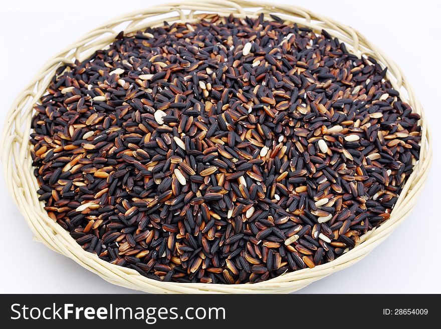 Black purple rice in bamboo basket on white background