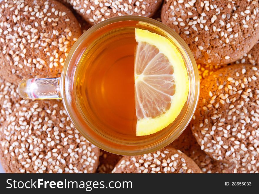 Cup of tea with lemon on a background of cookies