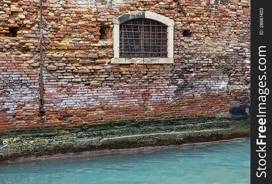 Detail of a brick wall of a Venetian house near a specific canal. Detail of a brick wall of a Venetian house near a specific canal.