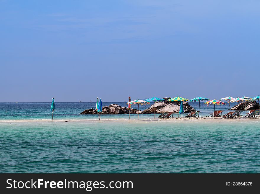 Umbrellas and beach chair on a beautiful beach in sunlight. Umbrellas and beach chair on a beautiful beach in sunlight