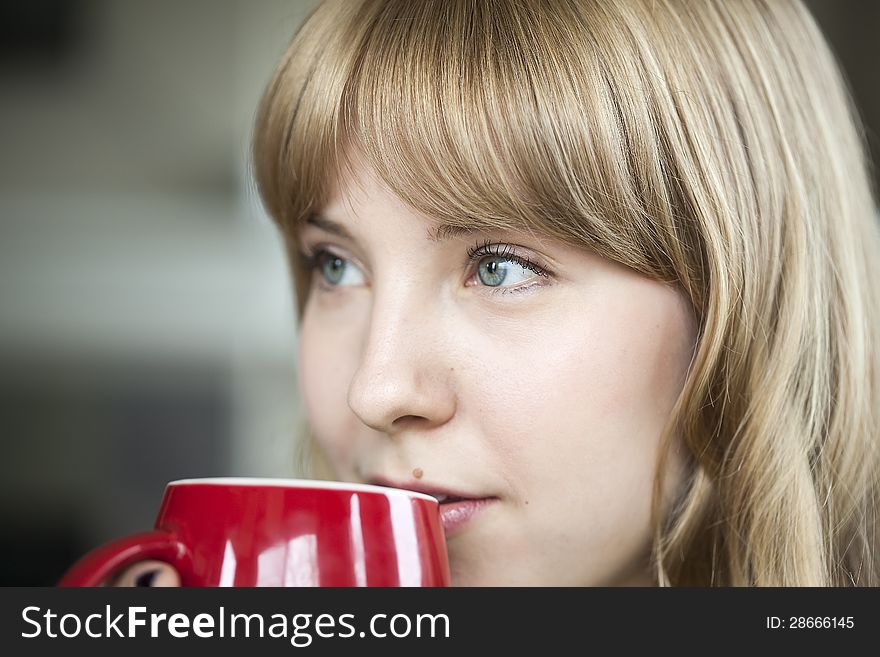 Portrait of a young woman  holding a cup of coffee. Portrait of a young woman  holding a cup of coffee.