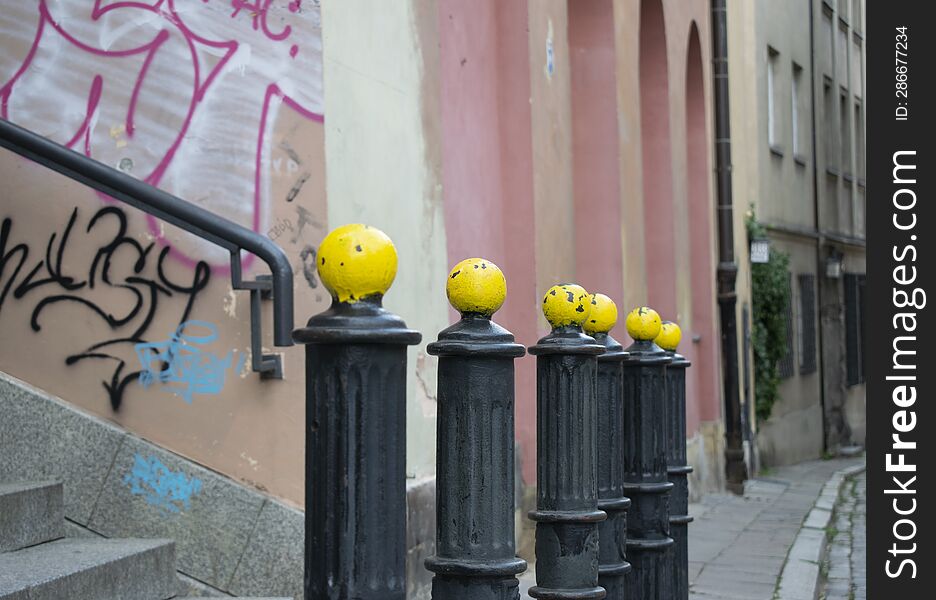 An old city street with yellow-headed posts placed in perspective