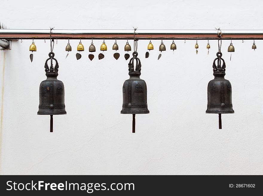 Three bells hanging on pillars at white wall. Three bells hanging on pillars at white wall.