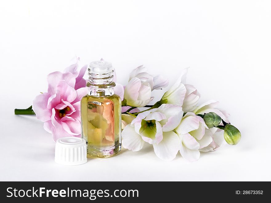 Vial with essential oil and pink flowers. Vial with essential oil and pink flowers