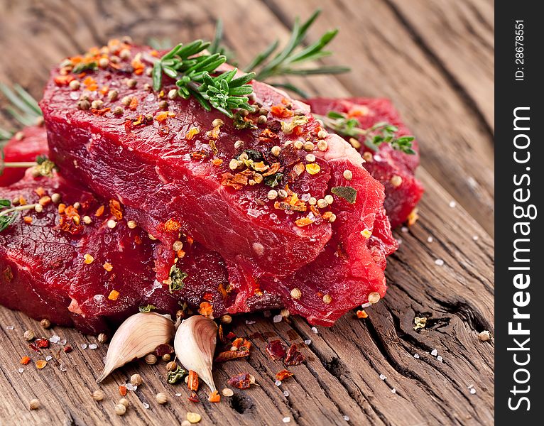 Raw beef steak on a dark wooden table. Raw beef steak on a dark wooden table.