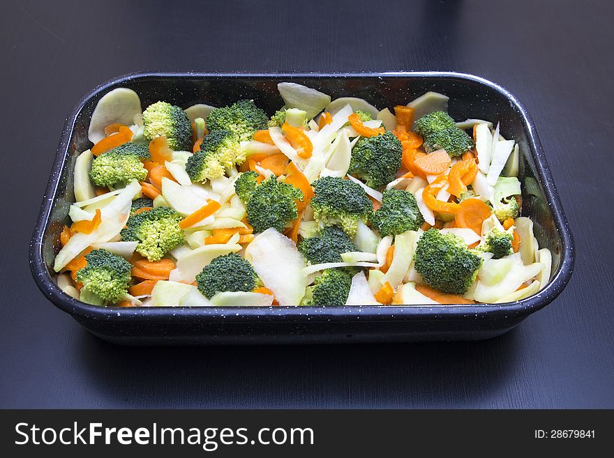 Fresh vegetables ready to cook on a black table