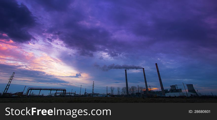Coal powered plant and smoke stacks under dramatic evening sky