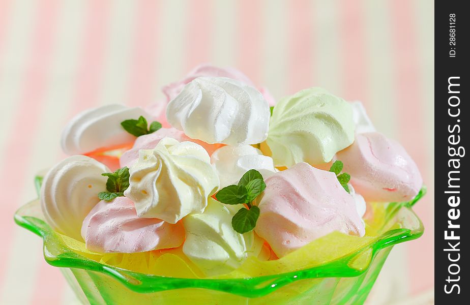 Close up image of meringue cookies on green glass bowl