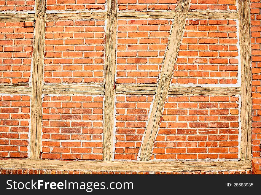 Old red brick wall with wooden beams as background closeup