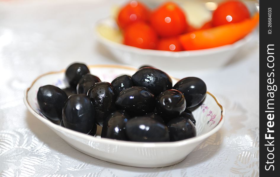 Plate with delicious big black olives served on the table. Plate with delicious big black olives served on the table