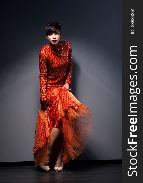 Trendy Brunette posing in Red Dress. Studio Shot