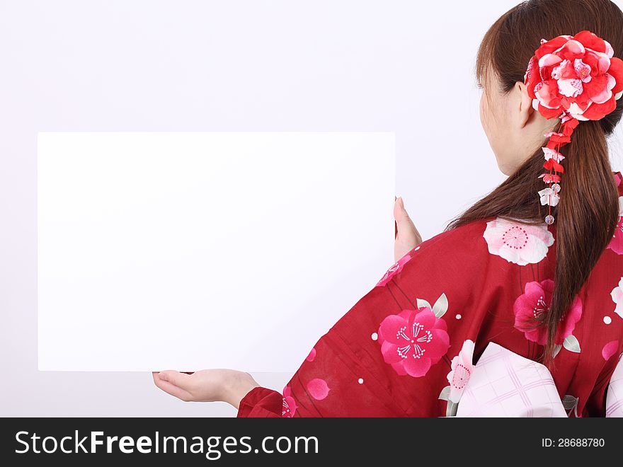 Rear view of young asian woman in traditional clothes of kimono holding a blank board