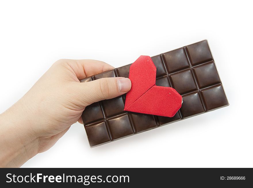 The man's hand holds a Valentine's Day card and chocolate. The man's hand holds a Valentine's Day card and chocolate