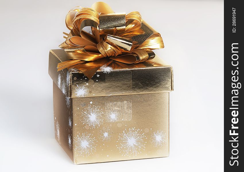 Gift packed into a gilded foil and decorated with a bow