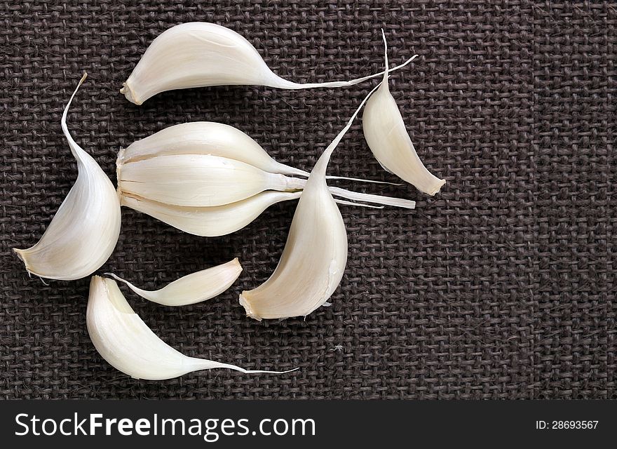 Fresh organic garlic cloves on jute cloth