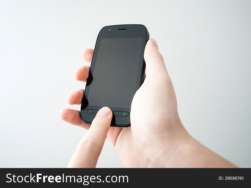 Hand holding mobile black smart phone on white background. Hand holding mobile black smart phone on white background