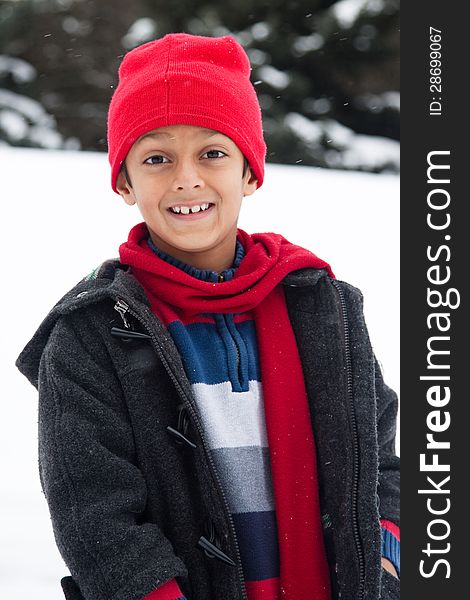 Happy East Indian boy playing in the snow