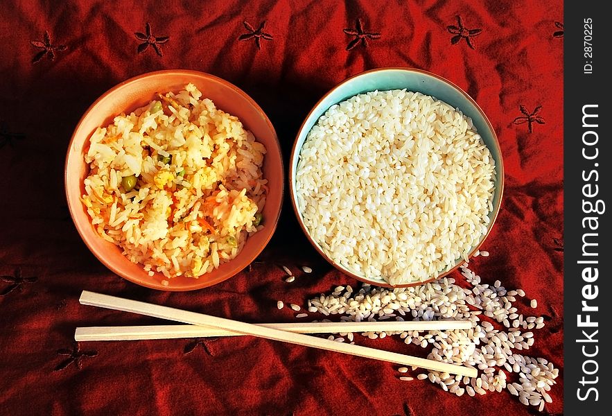 Prepared and uncooked rice in bowls on a oriental background. Prepared and uncooked rice in bowls on a oriental background.