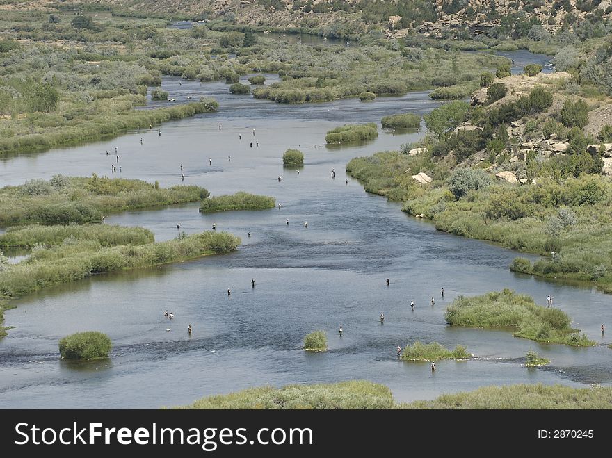 Fly fishers populate the qualtiy waters below the dam at the San Juan River Reservoir Northwestern New Mexico. Fly fishers populate the qualtiy waters below the dam at the San Juan River Reservoir Northwestern New Mexico.