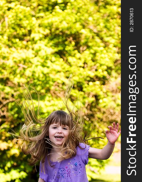 Happy little girl on down-side of a jump, her hair flying high. Happy little girl on down-side of a jump, her hair flying high.
