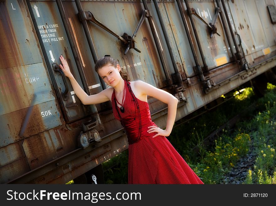 Beautiful young girl in an evening gown by a rusty old boxcar. Beautiful young girl in an evening gown by a rusty old boxcar.