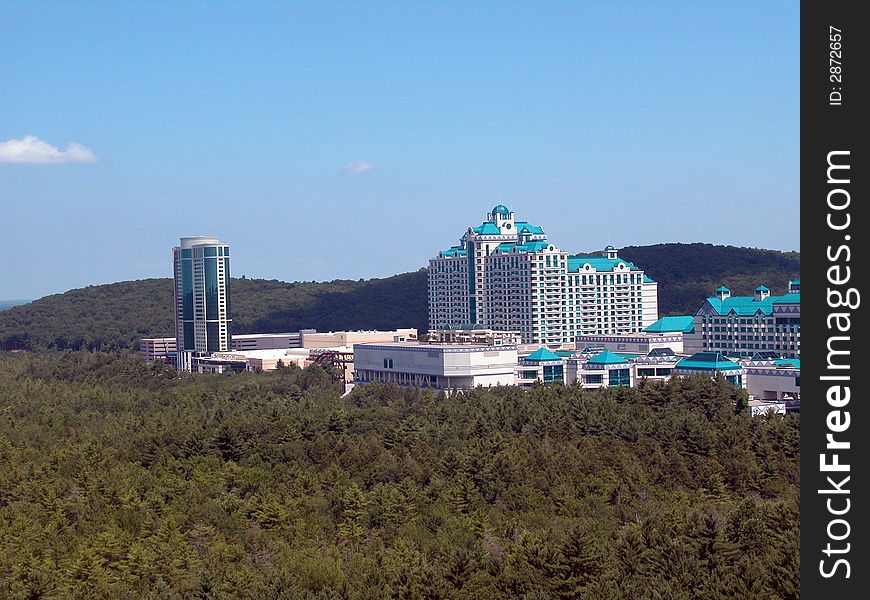 A distant resort can be seen in this arial view looking from above the trees.