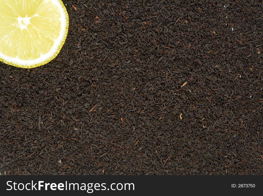 Lemon with black tea leaves background. Lemon with black tea leaves background