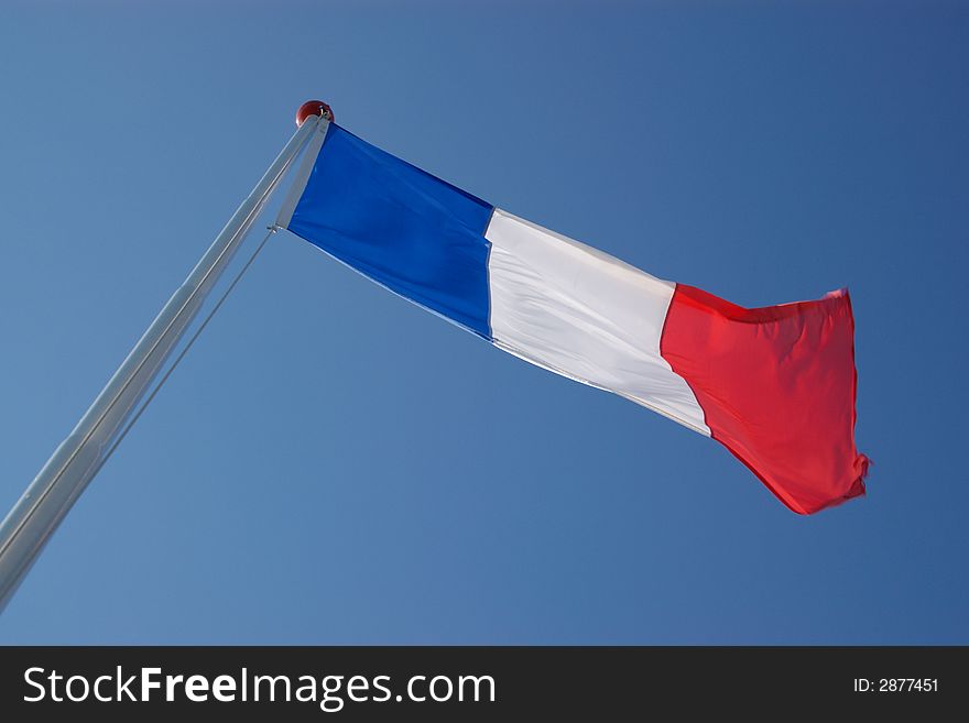 French national flag on metallic mast in blue sky, windy, horizontal. French national flag on metallic mast in blue sky, windy, horizontal