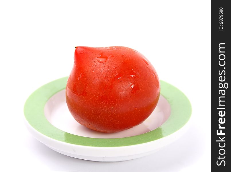 Single big red tomato on little saucer. Single big red tomato on little saucer