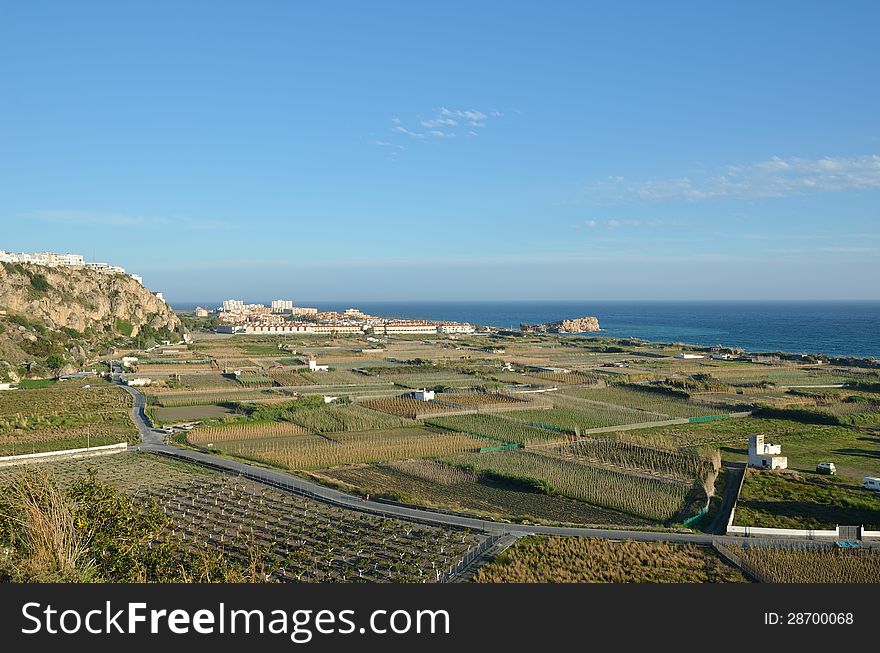 Fertile valley of the Spanish Mediterranean seacoast is photographed from above in spring. There are many fields and plantations. Fertile valley of the Spanish Mediterranean seacoast is photographed from above in spring. There are many fields and plantations.