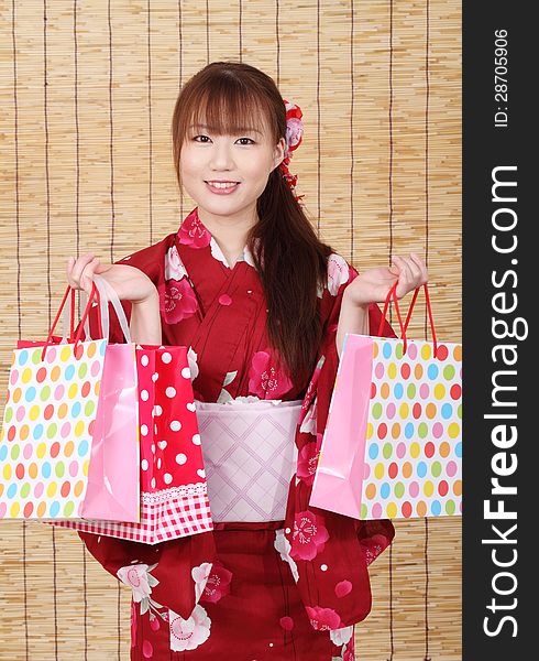 Young asian woman in traditional clothes of kimono with shopping bags. Young asian woman in traditional clothes of kimono with shopping bags